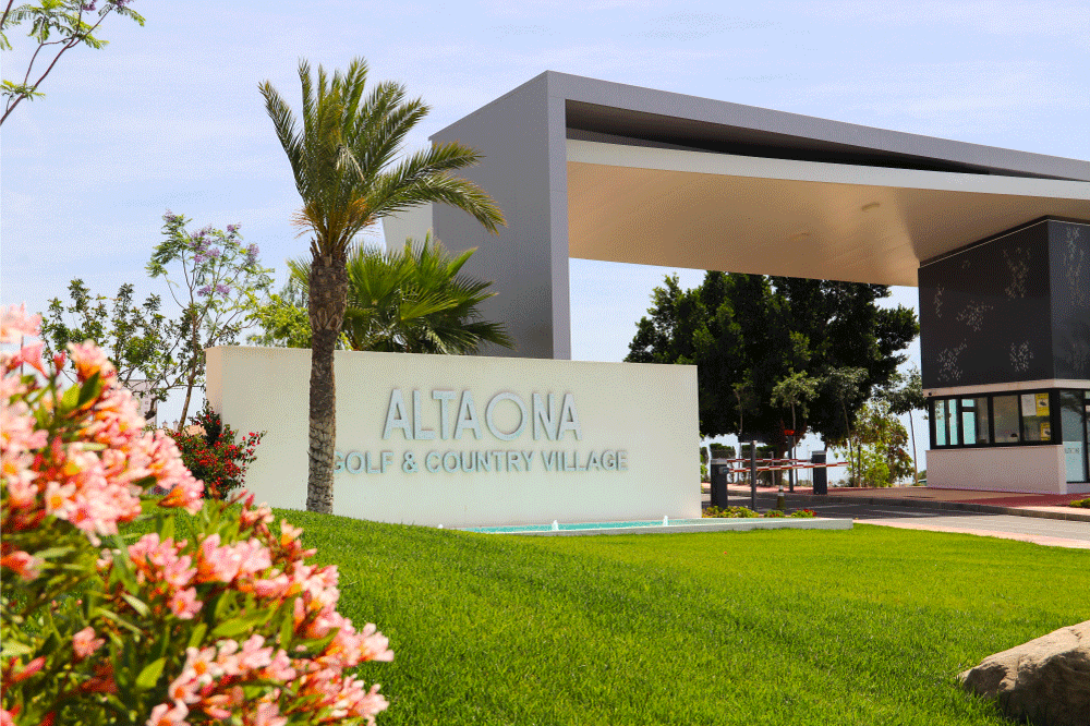 Main entrance of Altaona Sports & Wellness Resort in Murcia, surrounded by palm trees and Mediterranean landscape.