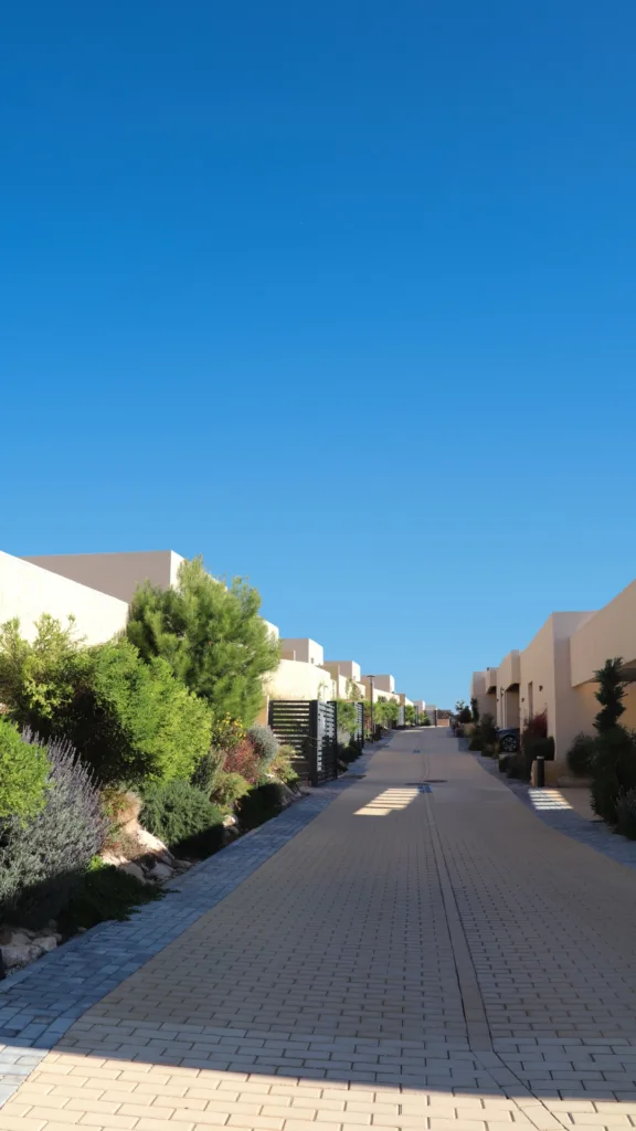 Residential street at Las Vistas Altaona with modern villas, landscaped gardens and clear Mediterranean sky in Murcia, Spain