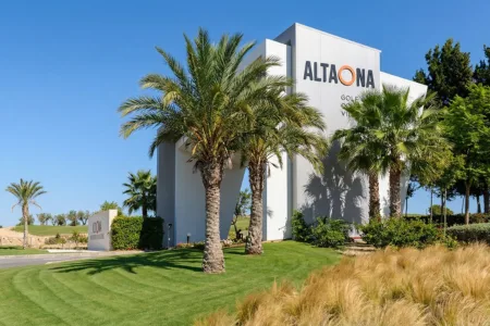 Entrance to Altaona Golf and Villas in Murcia, Spain, with palm trees and landscaped surroundings